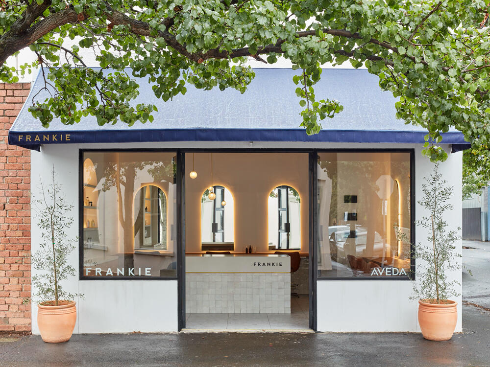 Frankie Salon, South Yarra Frankie Salon shopfront in South Yarra, Melbourne Australia with navy awning and olive trees